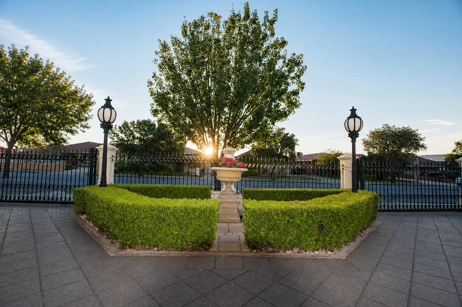 Formal front garden with clipped hedges and decorative fencing