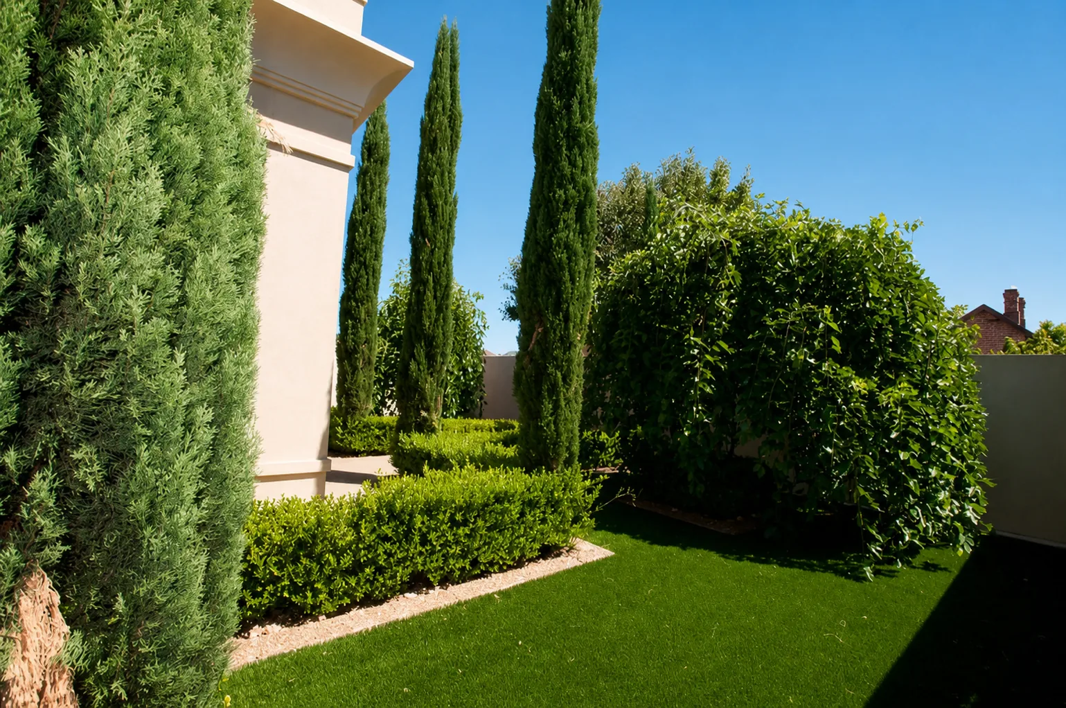 Structured formal garden with cypress trees and geometric hedging